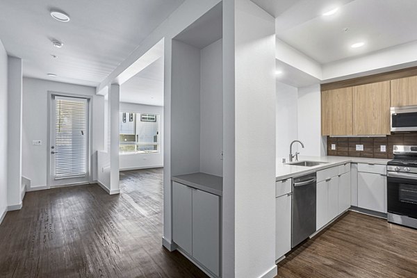 Modern kitchen with stainless steel appliances and granite countertops at Jefferson Cenza Apartments