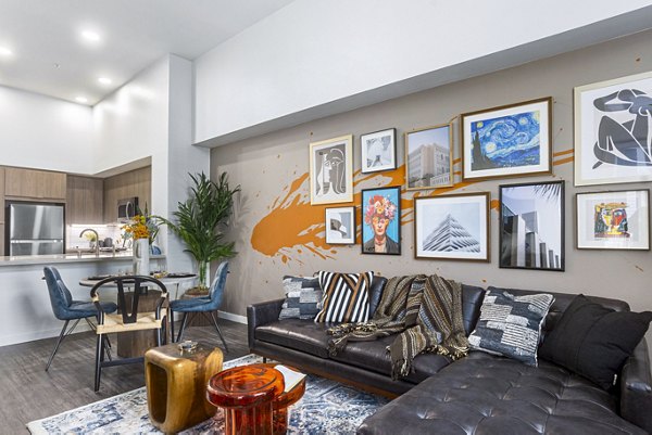 Living room featuring modern decor and large windows at Jefferson Cenza Apartments