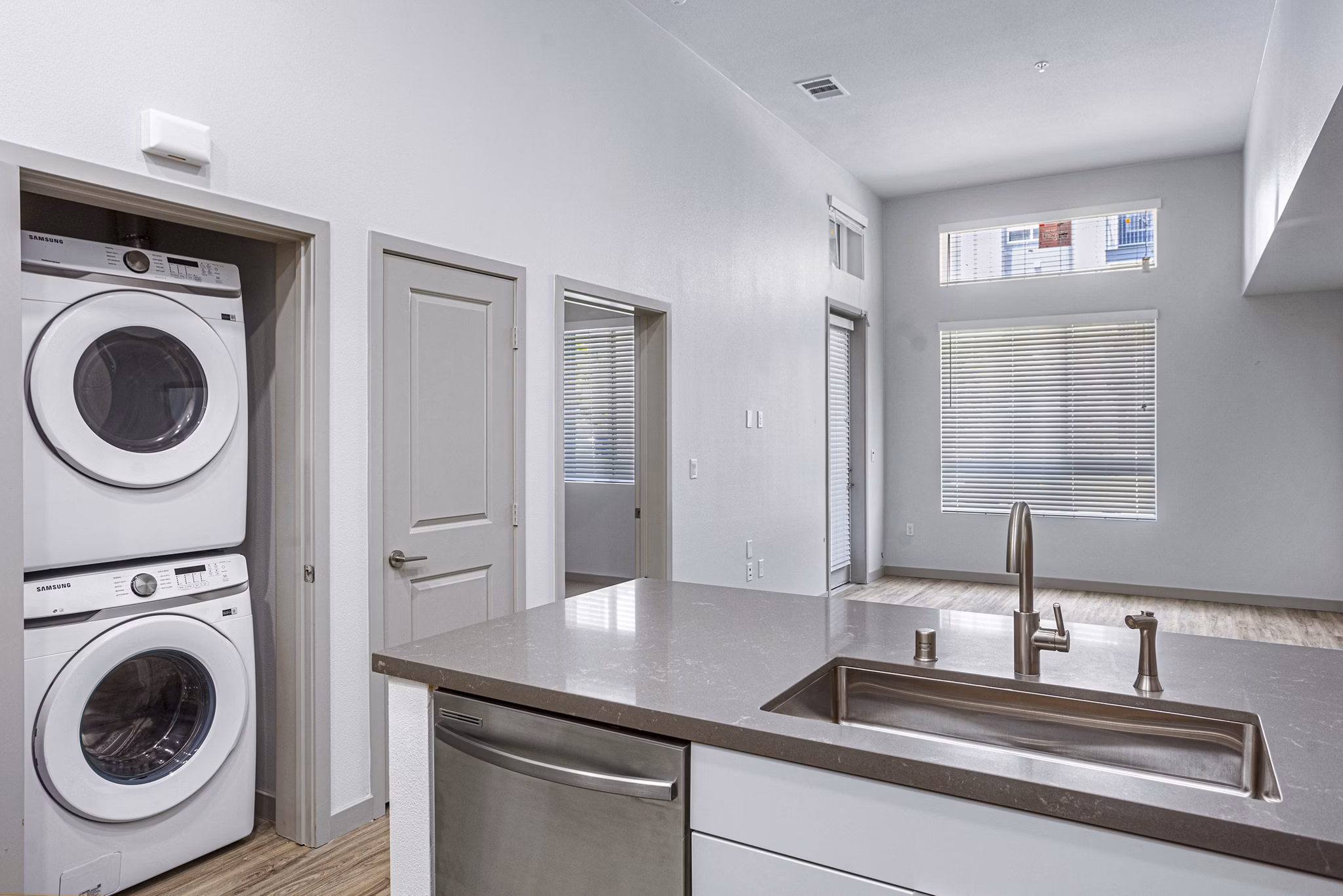 Modern kitchen with stainless steel appliances and in-unit laundry at Jefferson Cenza Apartments