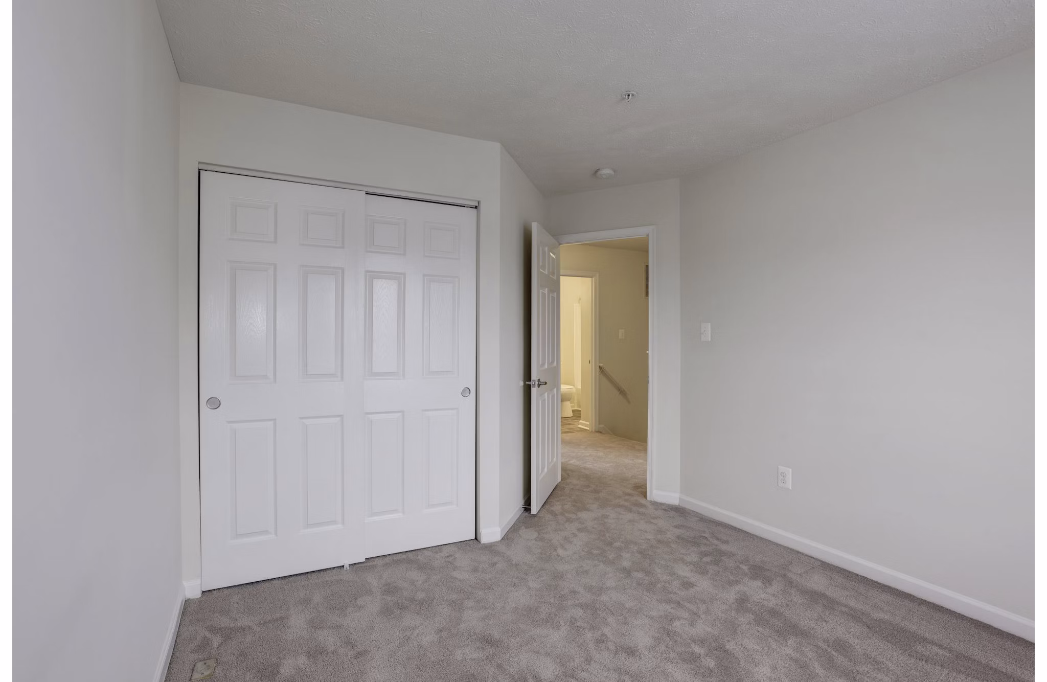 Cozy bedroom with modern furnishings at Kaiser Park Apartments featuring queen bed and soft lighting