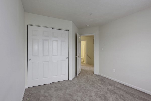 Cozy bedroom with modern furnishings at Kaiser Park Apartments featuring queen bed and soft lighting