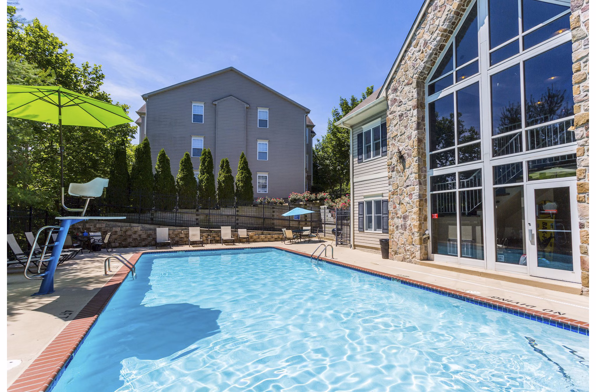 Resort-style swimming pool at Kaiser Park Apartments with relaxing lounge chairs and landscaped surroundings Luxury living in a serene environment