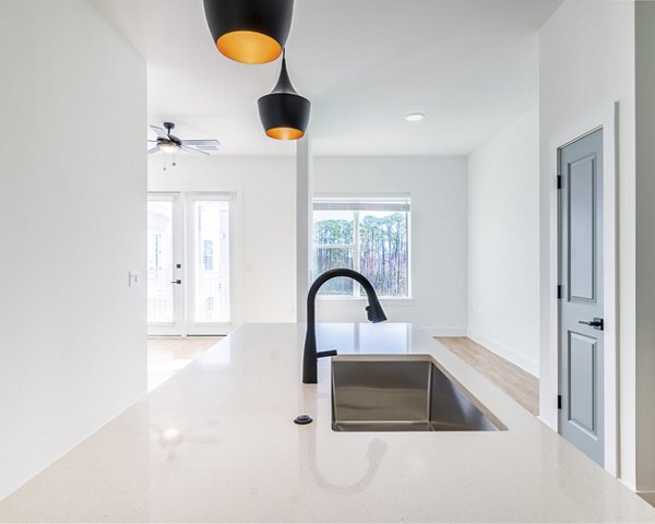 Spacious kitchen with modern appliances and marble countertops in Novel Nona Apartments