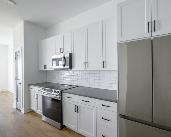 Modern kitchen with sleek countertops and stainless-steel appliances in Novel Nona Apartments