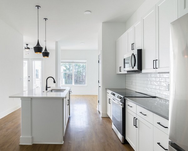 Modern kitchen with stainless steel appliances in luxury Novel Nona Apartments