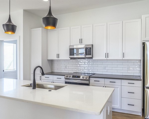 Modern kitchen with stainless steel appliances and granite countertops at Novel Nona Apartments, offering luxury living spaces