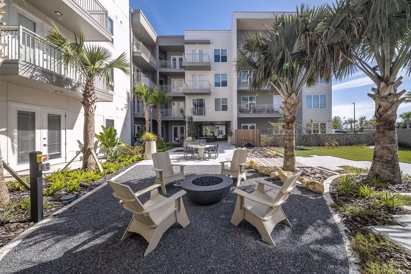 Patio featuring lounge furniture and lush landscaping at Novel Nona Apartments, providing a serene outdoor retreat for residents