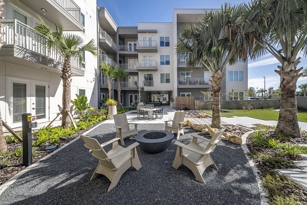 Patio featuring lounge furniture and lush landscaping at Novel Nona Apartments, providing a serene outdoor retreat for residents