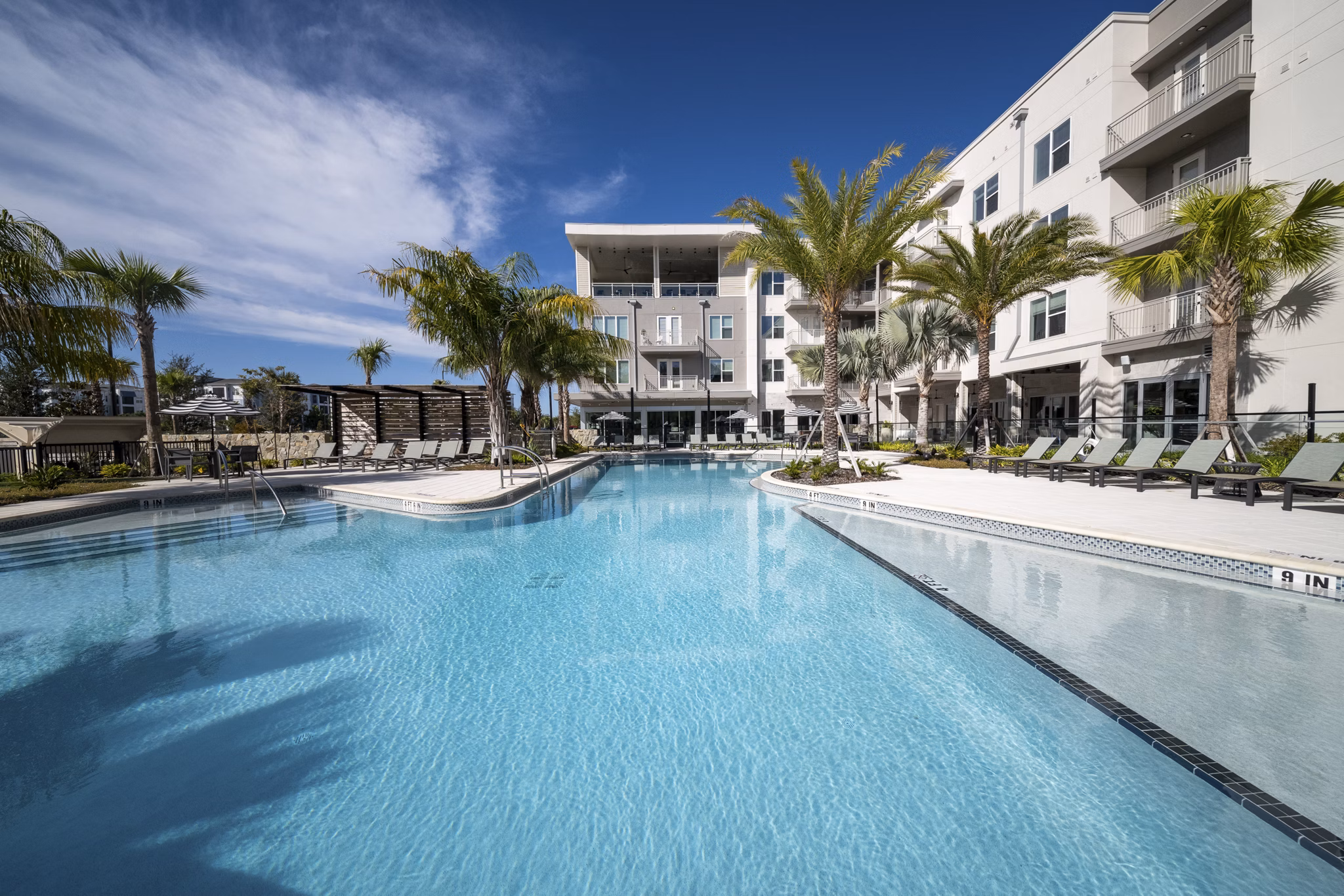 Luxurious swimming pool with lounge chairs at Novel Nona Apartments, offering a serene escape for residents