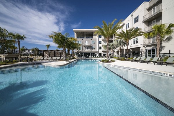 Luxurious swimming pool with lounge chairs at Novel Nona Apartments, offering a serene escape for residents