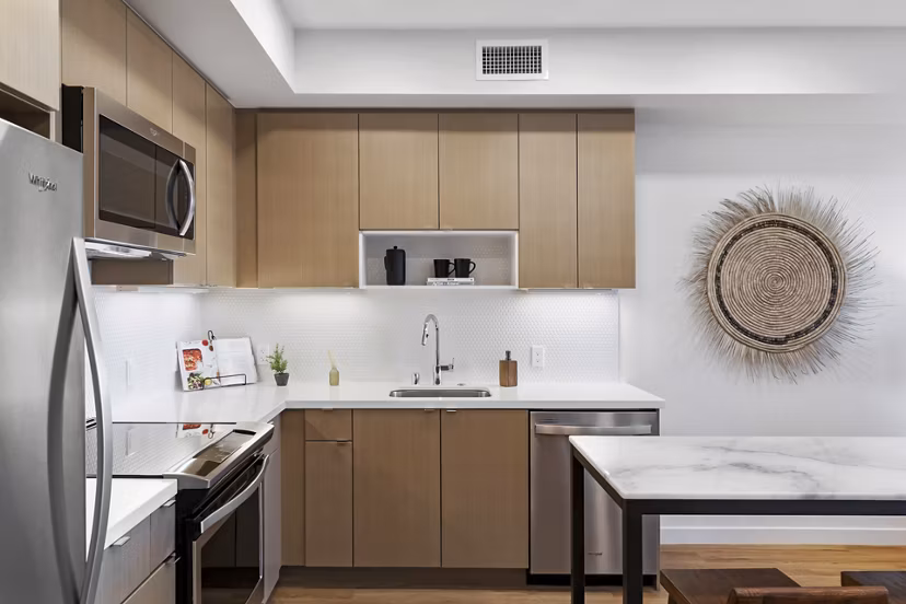 Lantana Uptown: Modern kitchen with stainless steel appliances and granite countertops in luxury apartments
