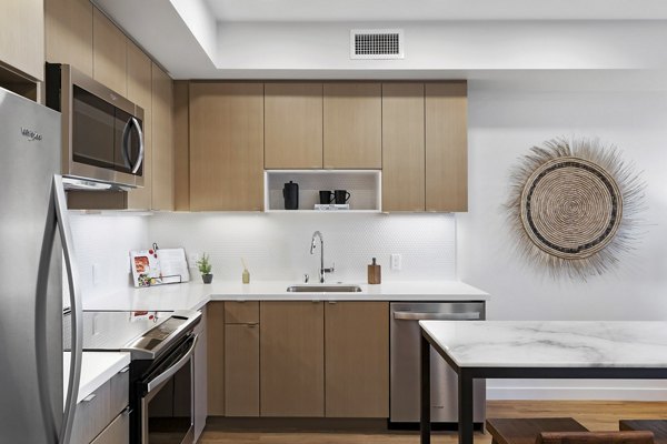 Lantana Uptown: Modern kitchen with stainless steel appliances and granite countertops in luxury apartments