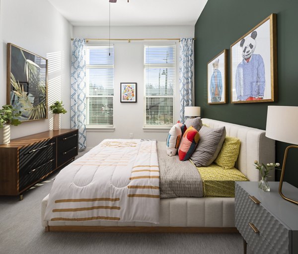 Elegant bedroom with modern decor at The Lowery Apartments, featuring plush bedding and stylish lighting for a luxurious living experience