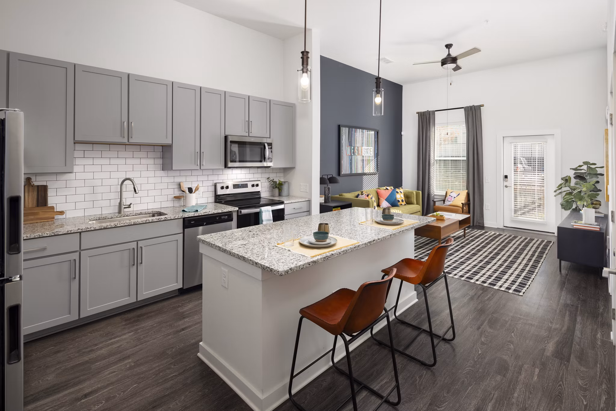 Modern kitchen with stainless steel appliances and granite countertops in The Lowery Apartments