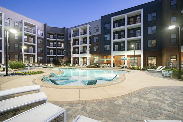 Poolside relaxation at The Lowery Apartments with luxury loungers and umbrellas