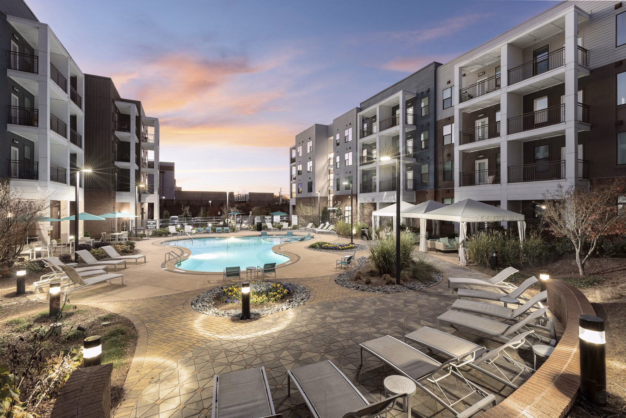 Chic resort-style pool surrounded by lush landscaping at The Lowery Apartments
