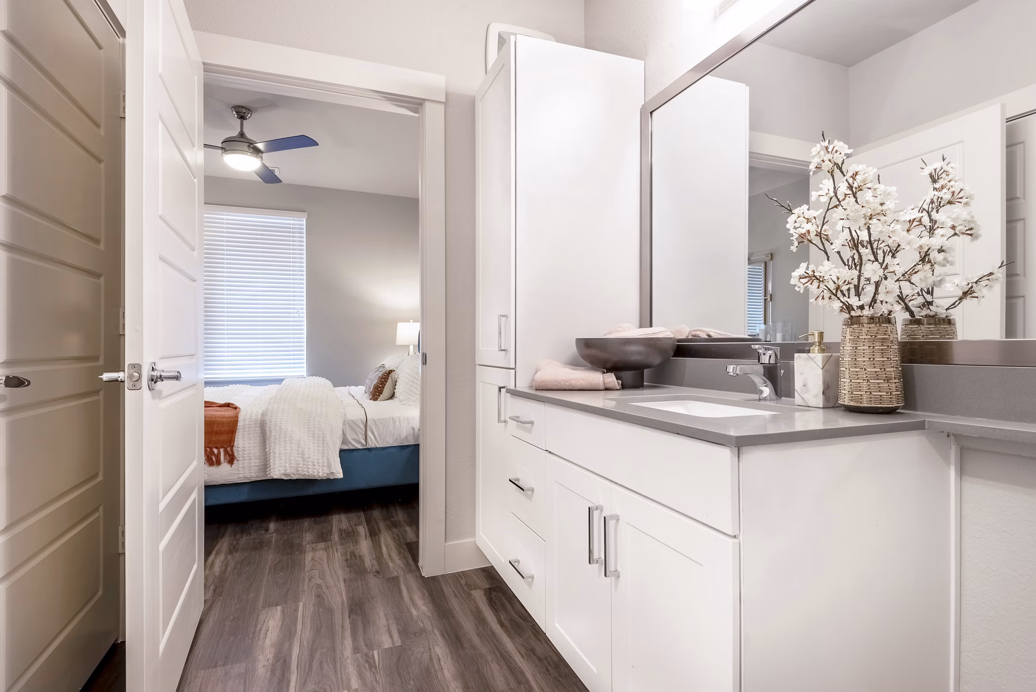 Cozy bedroom featuring stylish decor and large windows at Luxe at Mile High luxury apartments