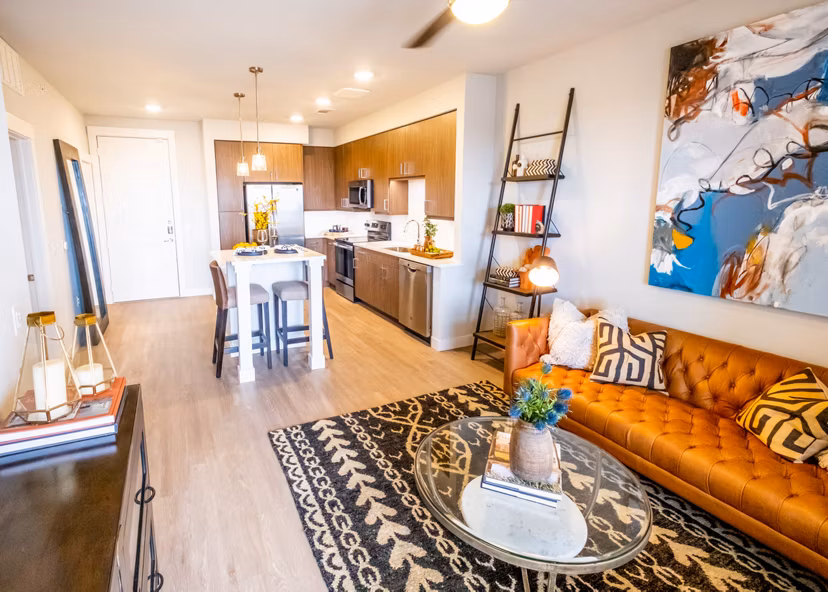 Stylish living room with modern furnishings and large windows in Luxe at Mile High luxury apartments