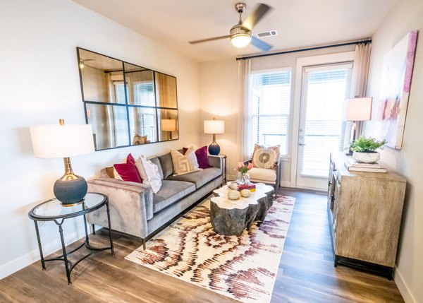Spacious living room with modern decor and city views at Luxe at Mile High luxury apartments