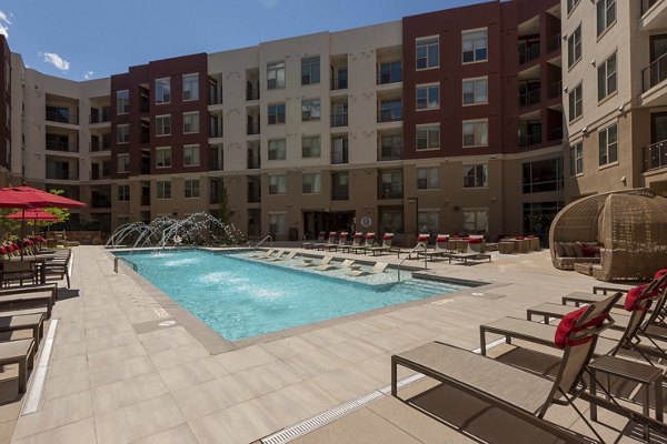 Luxurious pool area at Luxe at Mile High luxury apartments in Denver, featuring lounge chairs and scenic views