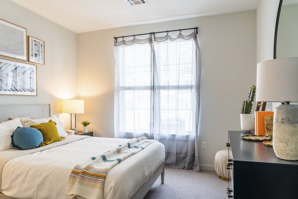 Cozy bedroom with plush bedding and modern decor at The Madison at Marshfield luxury apartments