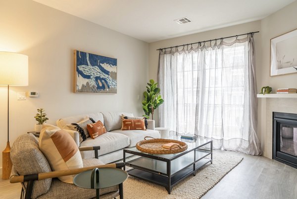 Spacious living room featuring modern decor and large windows in The Madison at Marshfield luxury apartments