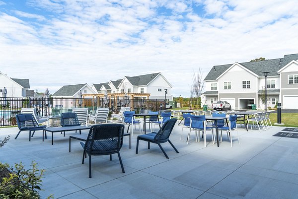 The Madison at Marshfield: Elegant outdoor patio space featuring seating and lush greenery