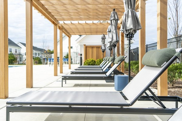 Patio with cozy seating and lush greenery at The Madison at Marshfield luxury apartments