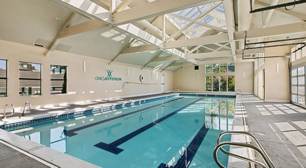 Luxurious poolside oasis at One Jefferson Apartments with sun loungers and landscaped gardens, ideal for relaxation and leisure activities