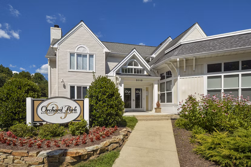 Orchard Park Apartments: Elegant building surrounded by lush greenery in a suburban setting