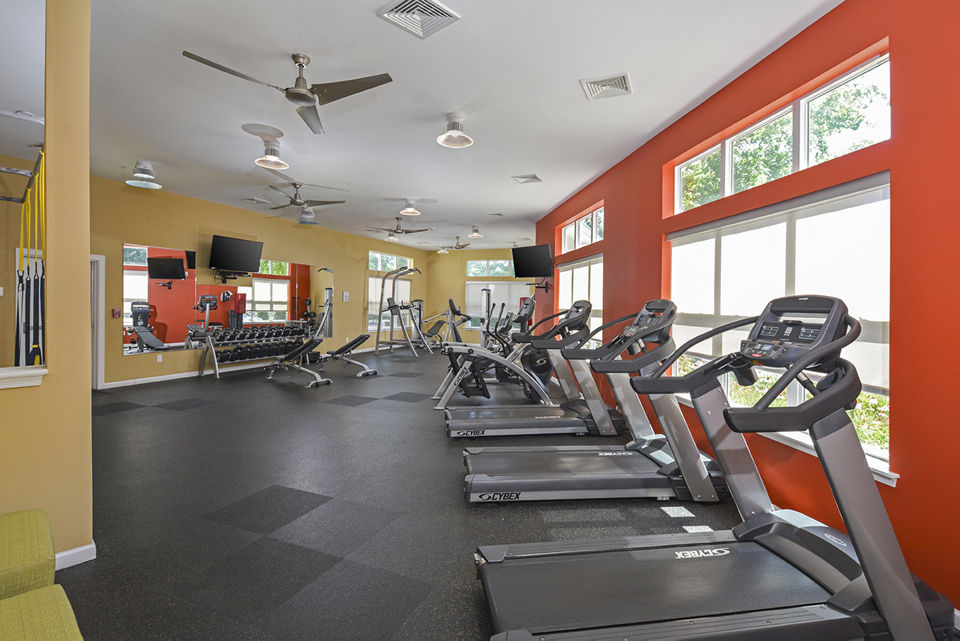 Well-equipped fitness center at Orchard Park Apartments with modern exercise machines and free weights, promoting active lifestyle and wellness
