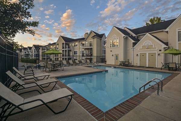Orchard Park Apartments: Relaxing pool area with lounge chairs surrounded by lush greenery enhances the luxury living experience