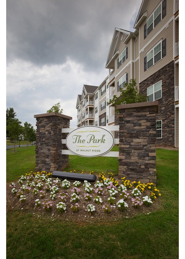 Building of The Park at Walnut Ridge Apartments featuring modern architecture in a lush setting, offering luxurious living spaces