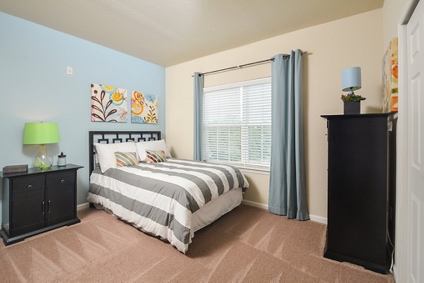 Cozy bedroom featuring modern furnishings at The Park at Walnut Ridge Apartments