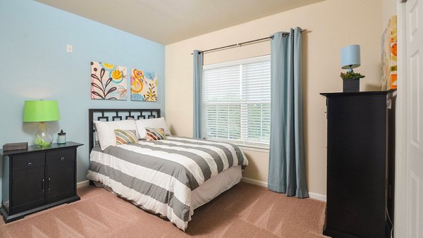 Bedroom with modern decor and ample natural light at The Park at Walnut Ridge Apartments