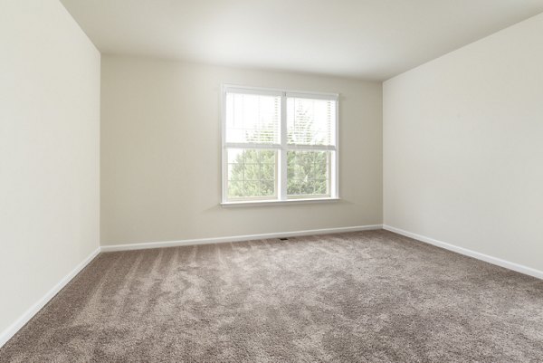 Modern living room featuring stylish furniture and large windows in Towns at Walnut Ridge Apartments