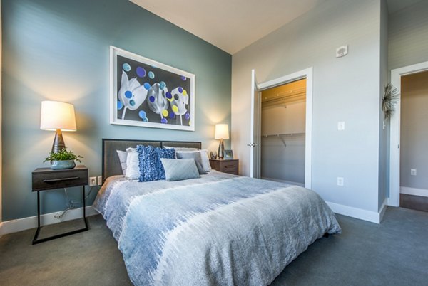 Stylish bedroom with modern decor at Re150 Apartments featuring luxury furnishings and ample natural light