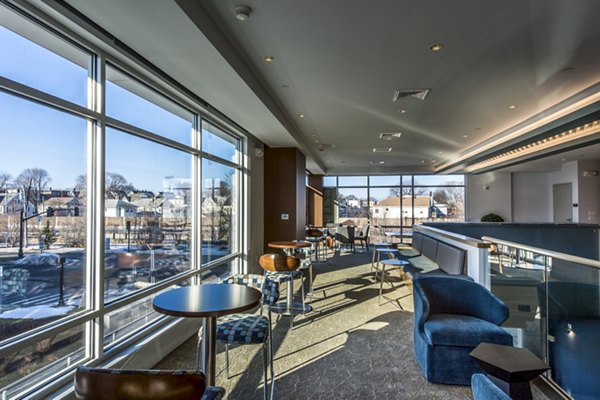 Modern clubhouse with cozy seating and large TV at Re150 Apartments