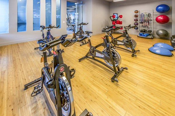 Yoga/spin studio with modern equipment at Re150 Apartments: Luxury fitness facilities for residents