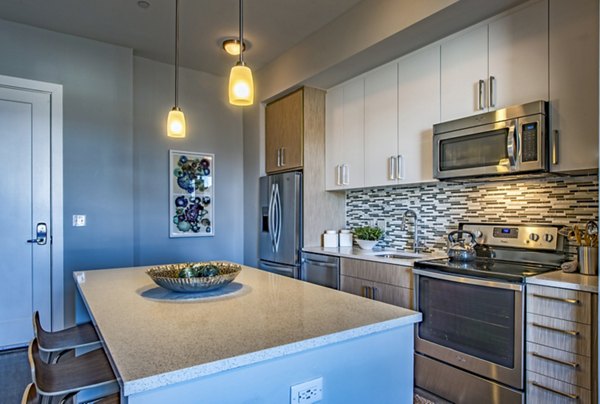 Modern kitchen with stainless steel appliances at Re150 Apartments