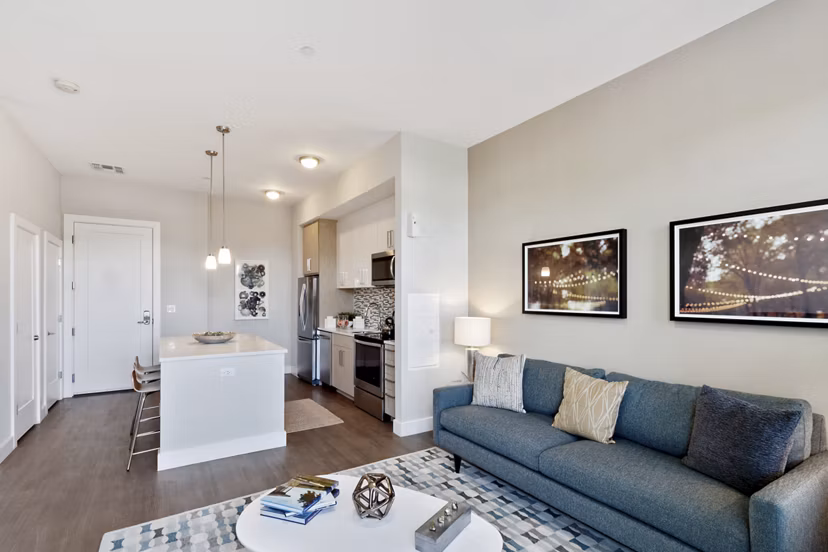 Spacious modern living room featuring sleek furnishings and large windows at Re150 Apartments, luxury Greystar property in vibrant Boston community