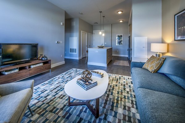 Spacious modern living room featuring sleek furnishings and large windows at Re150 Apartments, luxury Greystar property in vibrant Boston community