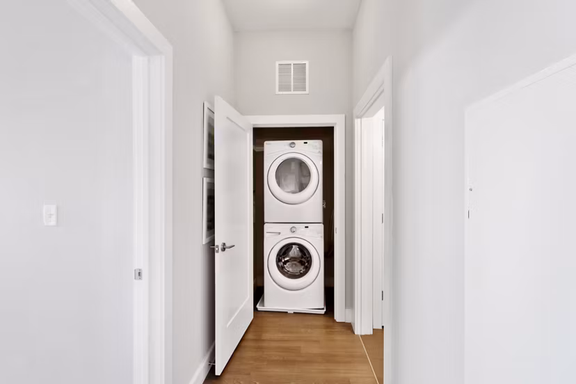 Laundry room equipped with modern appliances in Re150 Apartments