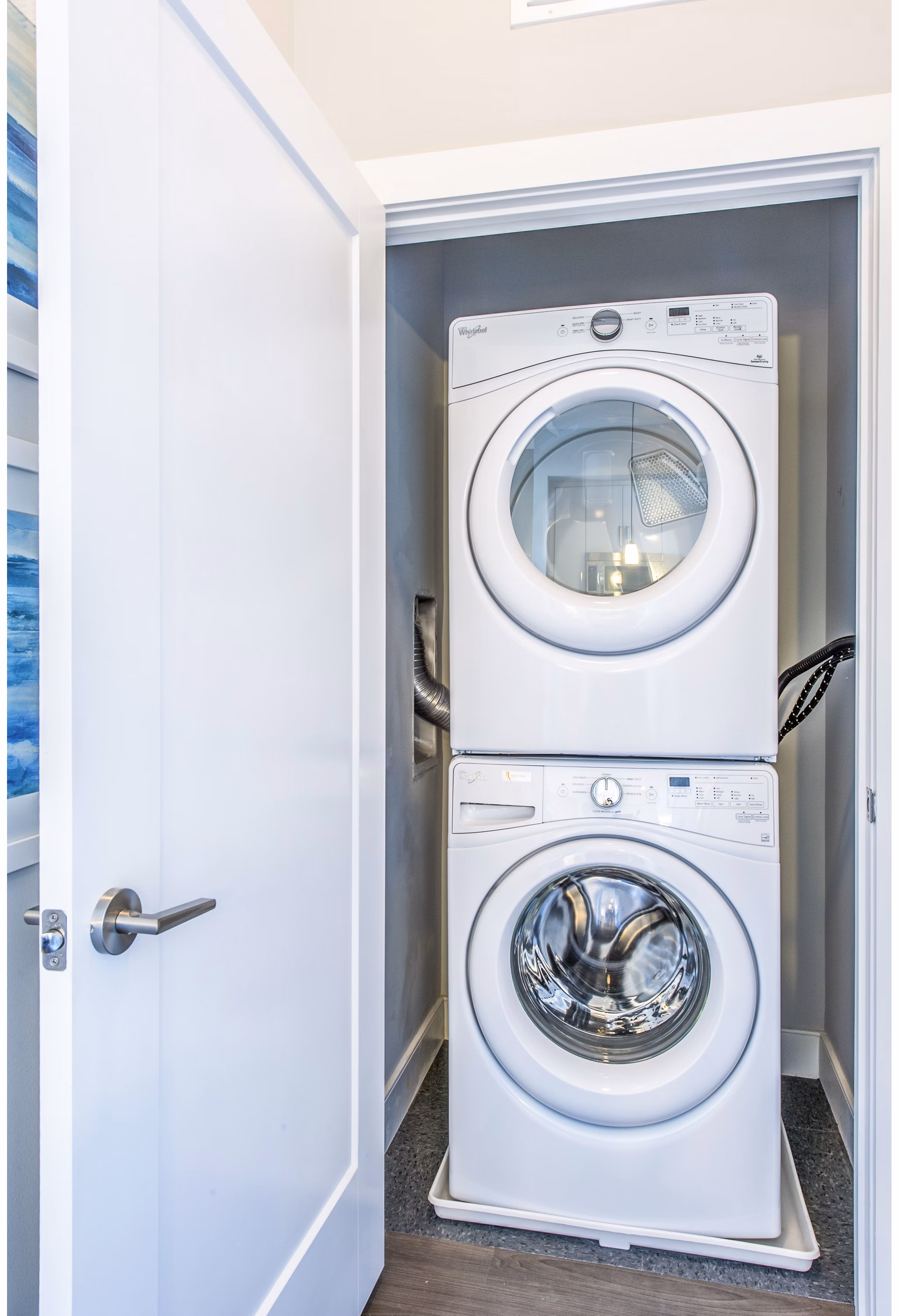 Laundry room equipped with modern appliances in Re150 Apartments