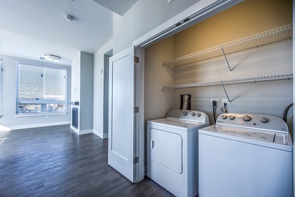 Laundry room with modern appliances at Re150 Apartments