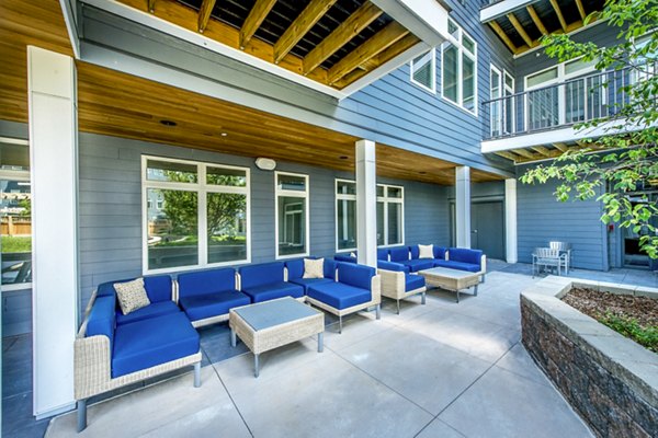 Stylish outdoor patio at Re150 Apartments featuring modern seating and lush greenery