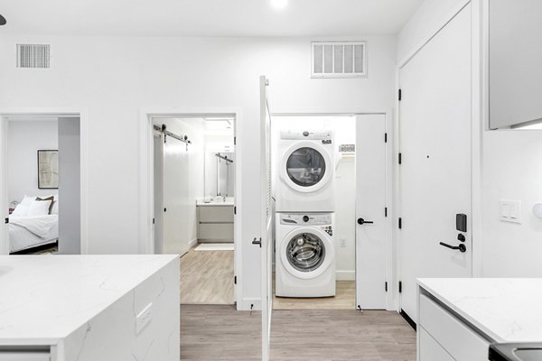 Laundry room with modern washer-dryer setup in Rinrose Apartments, Greystar luxury community