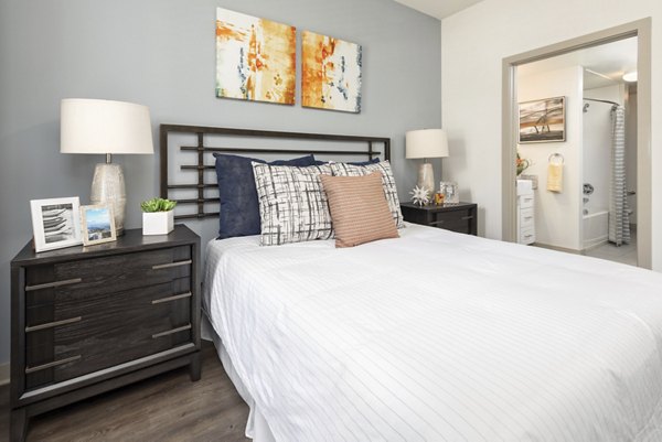 Cozy bedroom with modern decor and ample natural light at Solara Apartments