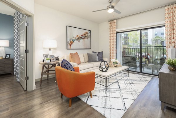 Spacious living room with modern decor and natural light at Solara Apartments