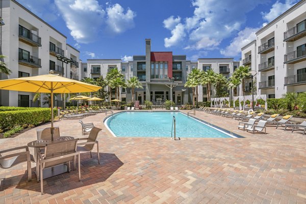 Resort-style swimming pool at Solara Apartments with luxurious lounging areas and lush landscaping